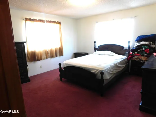 a large bed sitting in a bedroom next to a window