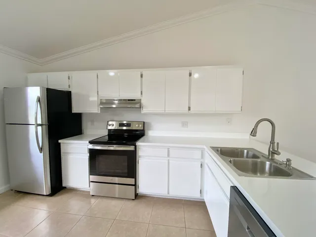 a kitchen with a sink stove and refrigerator