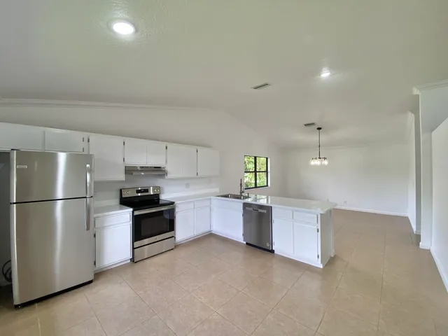 a kitchen with a refrigerator and a stove top oven