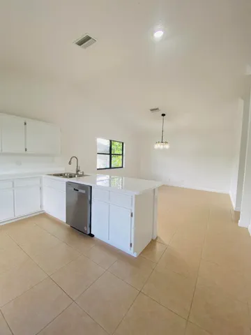 a large white kitchen with cabinets