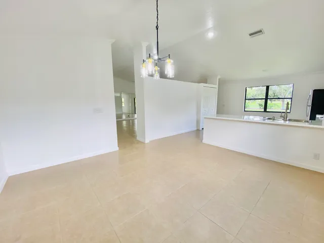 a view of a kitchen with a sink and chandelier
