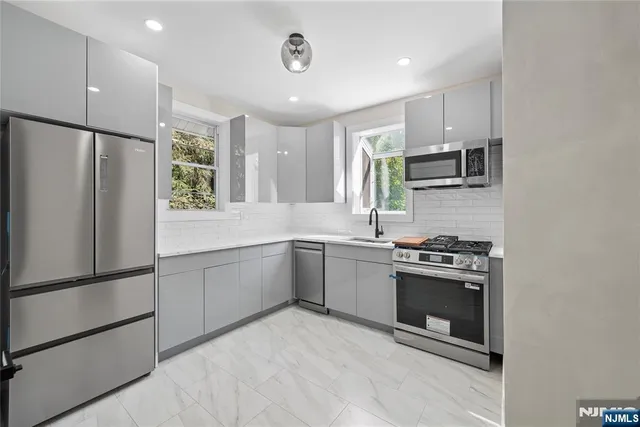 a kitchen with stainless steel appliances granite countertop a refrigerator sink and stove