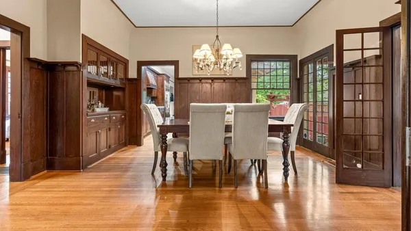 a view of a dining room with furniture a chandelier and wooden floor