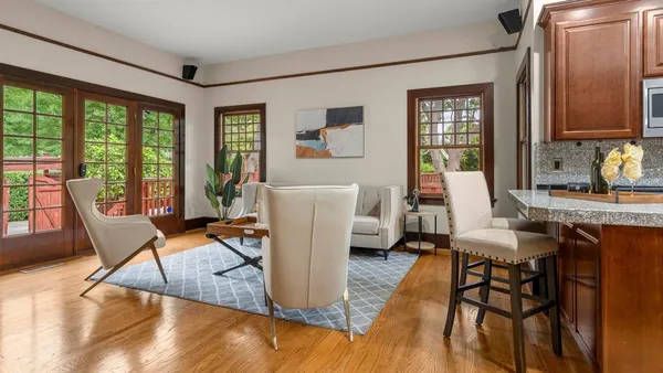 a living room with furniture a large window and wooden floor