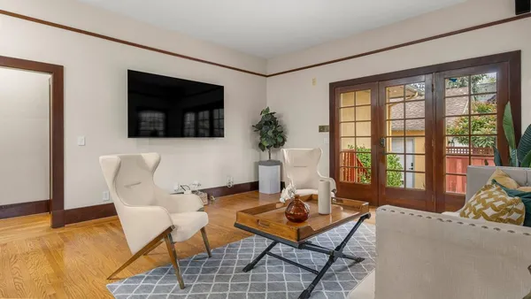 a living room with furniture a flat screen tv and a large window