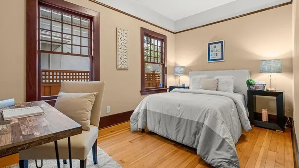 a bedroom with a bed and wooden floor