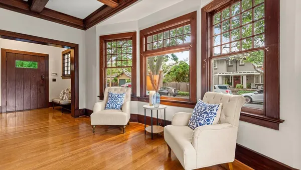 a living room with furniture and floor to ceiling windows