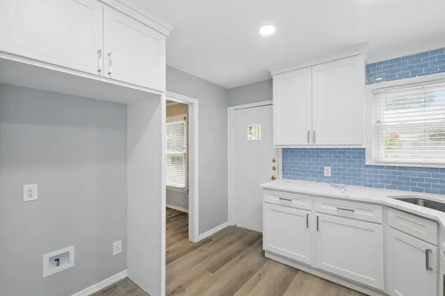 a kitchen with white cabinets and sink