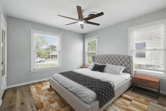 a bedroom with a large bed and two windows