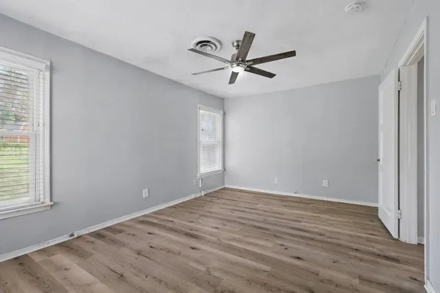 a view of a big room with wooden floor closet and windows