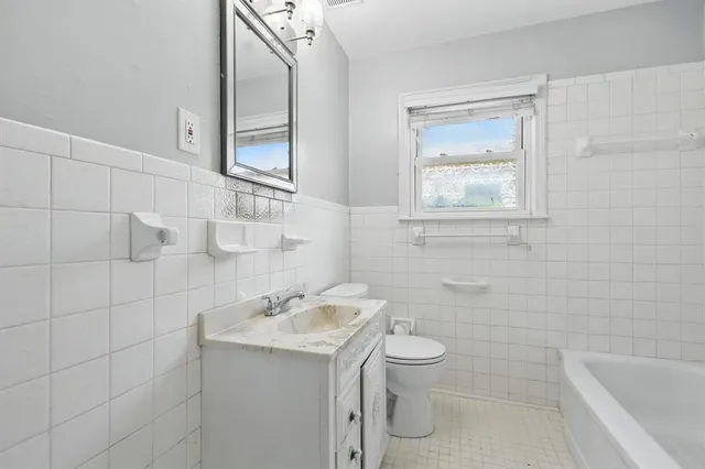 a bathroom with a granite countertop toilet a sink and mirror