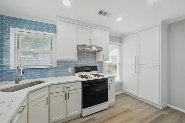 a kitchen with cabinets appliances and a sink