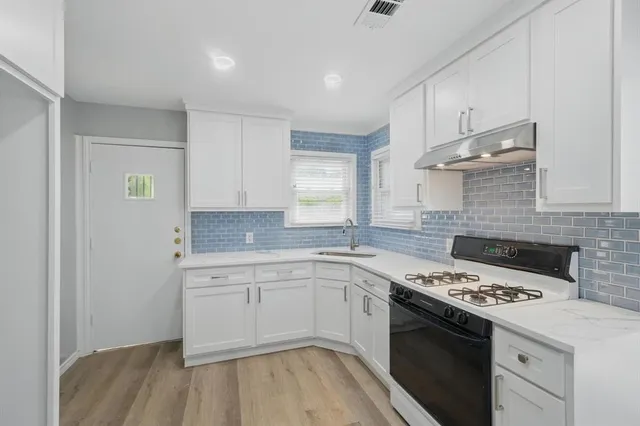 a kitchen with a sink stove and cabinets