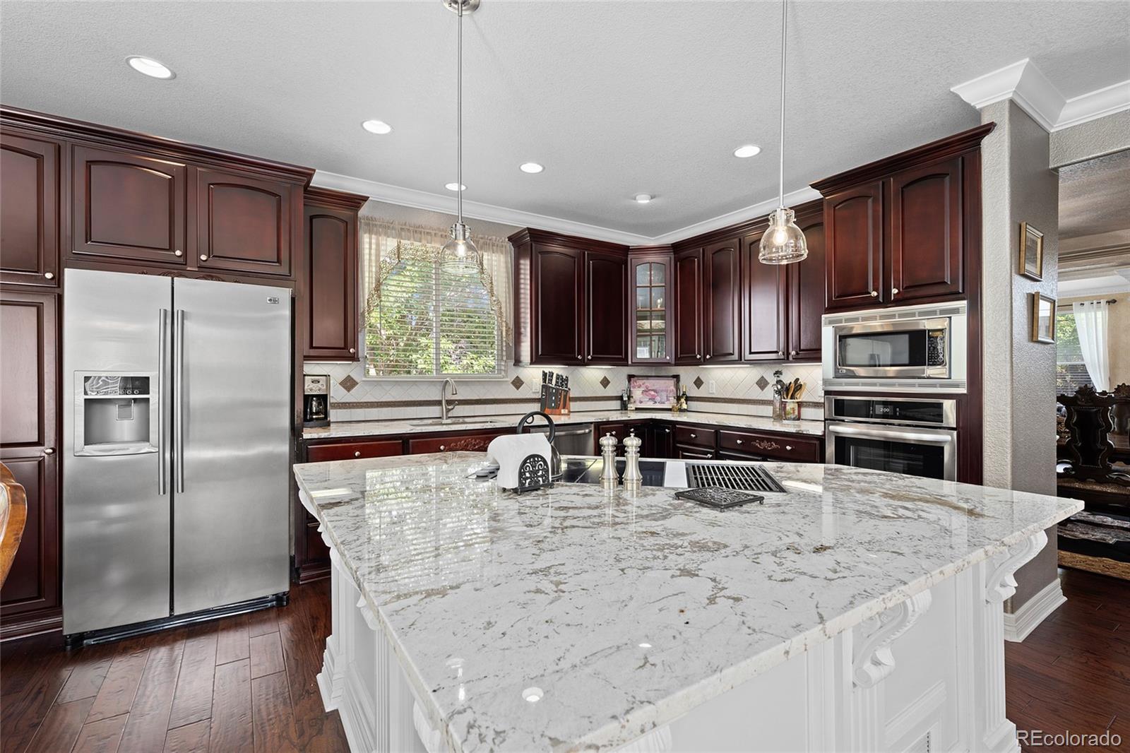 a kitchen with stainless steel appliances granite countertop a refrigerator a stove top oven a sink and dishwasher