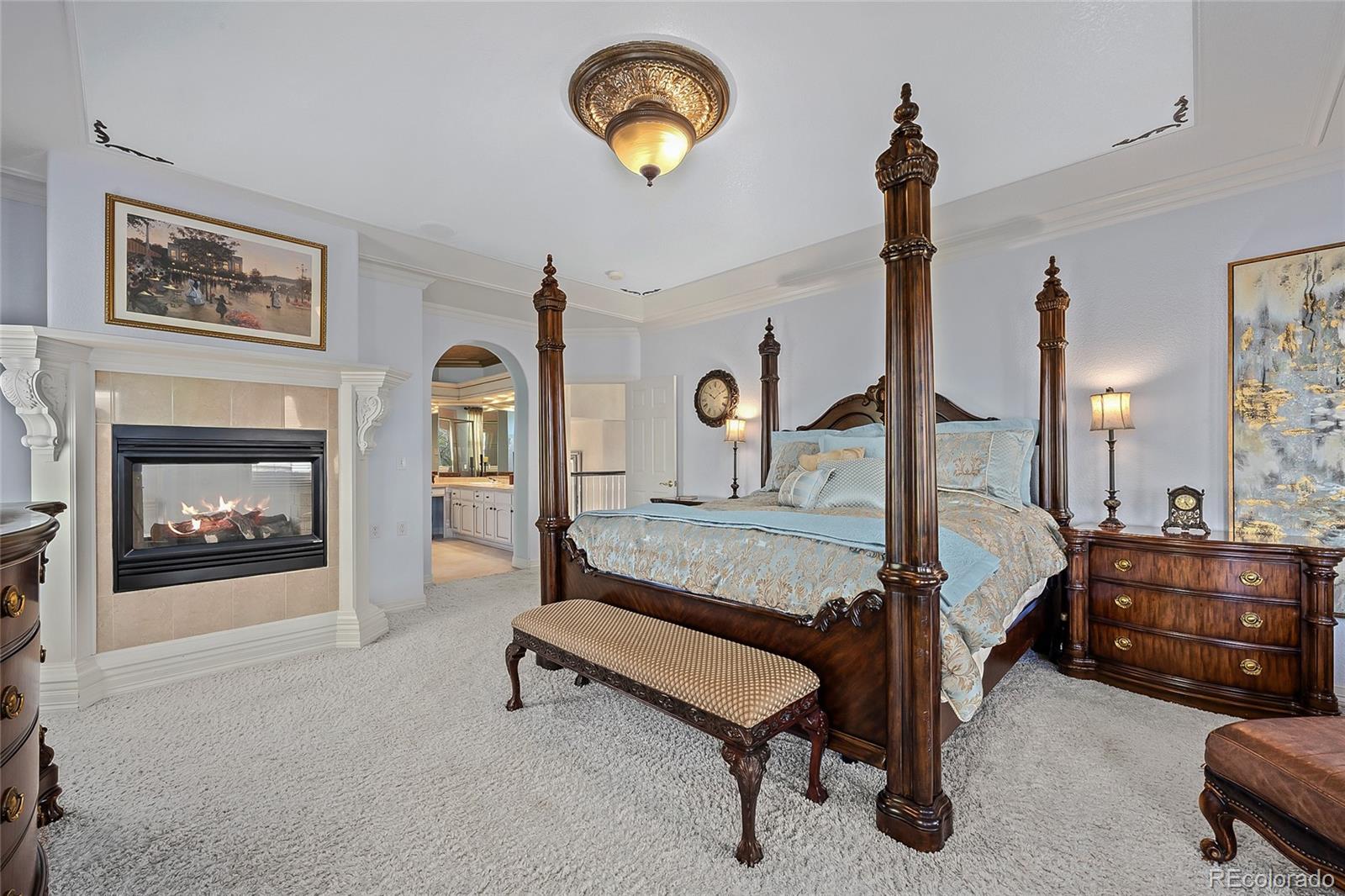 6374 Umber Circle Arvada, CO 80403 - Photo 16 of 33 a spacious bedroom with a bed and a chandelier