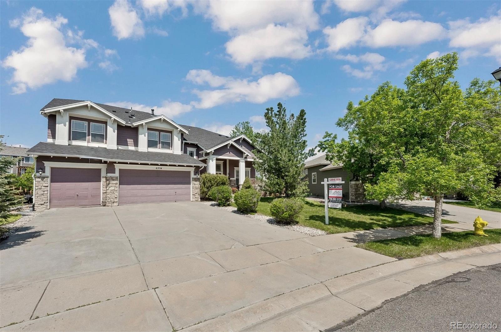 6374 Umber Circle Arvada, CO 80403 - Photo 2 of 33 a front view of a house with a yard and garage