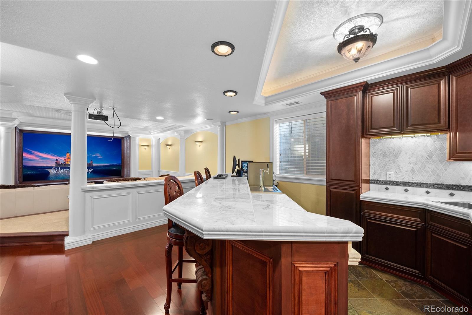 6374 Umber Circle Arvada, CO 80403 - Photo 24 of 33 a kitchen with stainless steel appliances kitchen island granite countertop a table chairs in it and wooden floors