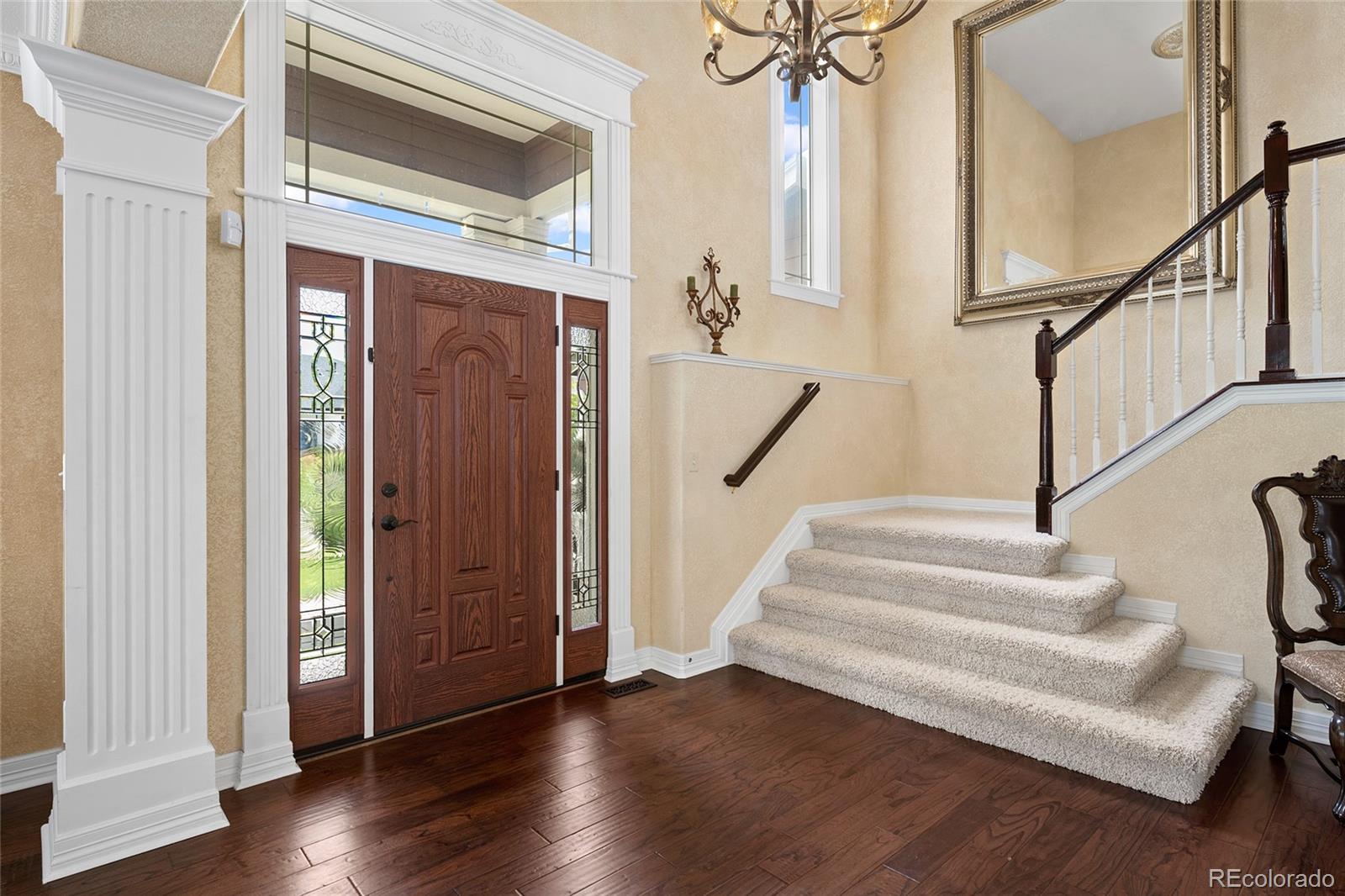 6374 Umber Circle Arvada, CO 80403 - Photo 4 of 33 a view of entryway with wooden floor and stairs