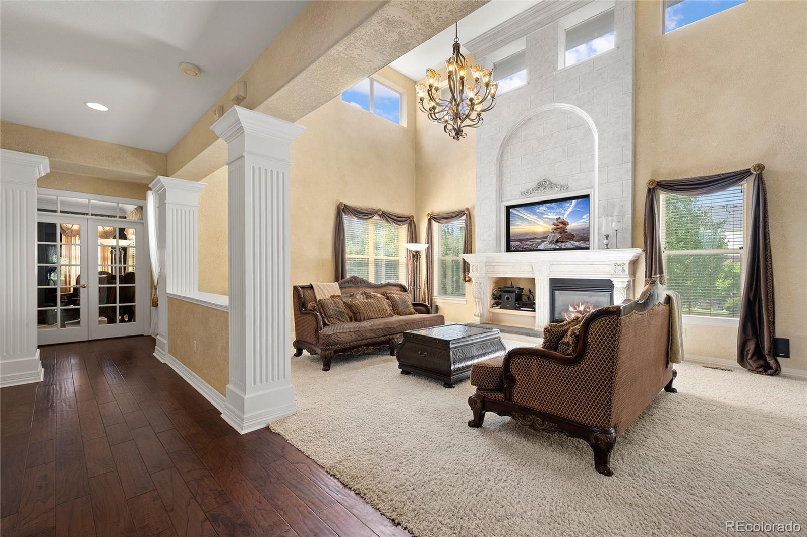 6374 Umber Circle Arvada, CO 80403 - Photo 9 of 33 a living room with furniture a fireplace and a chandelier