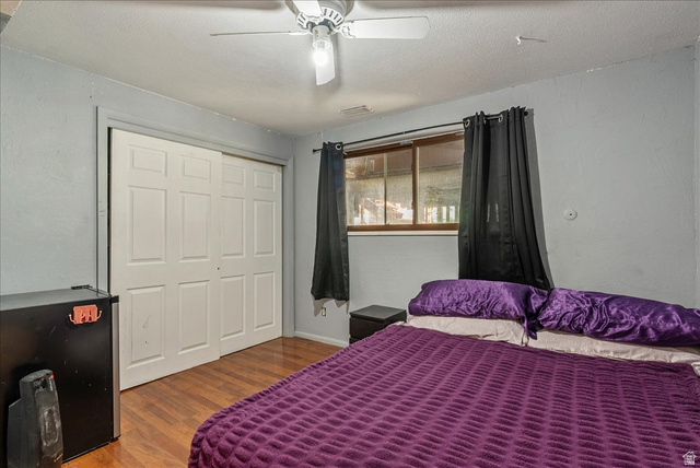 11 South Clark Lane Elk Ridge, UT 84651 - Photo 28 of 46 Bedroom featuring wood finished floors, a closet, a textured ceiling, ceiling fan