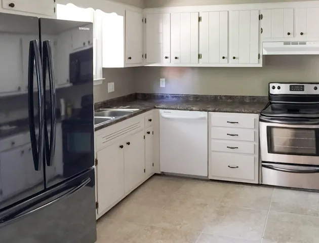 a kitchen with white cabinets and stainless steel appliances