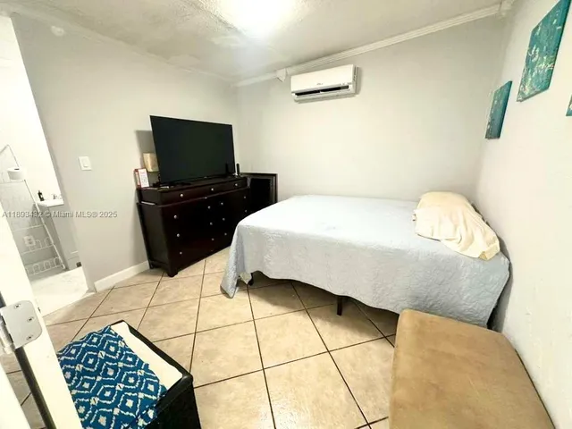 a bedroom with a bed and a flat screen tv
