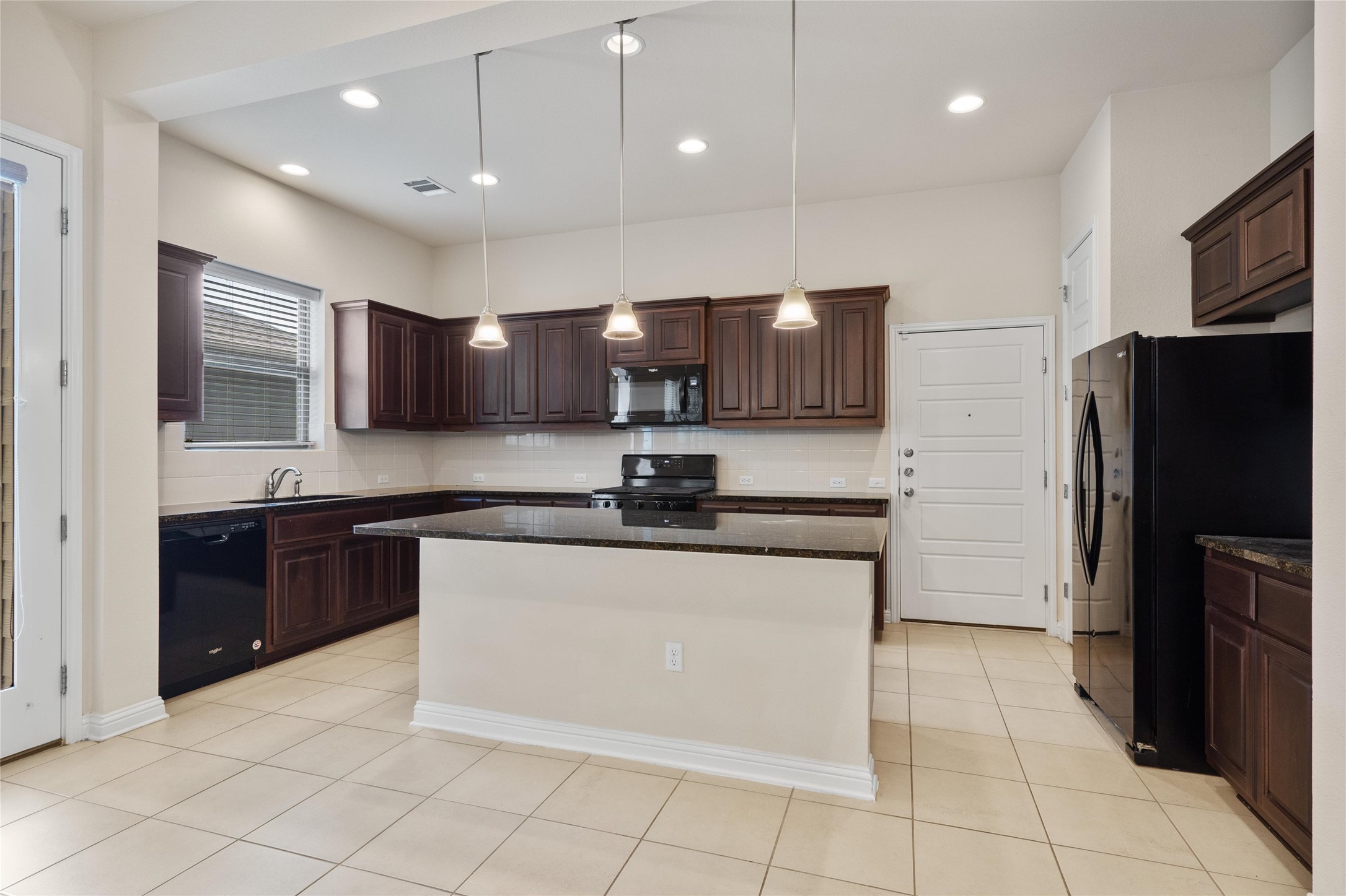 6907 Idea Road Austin, TX 78741 - Photo 6 of 36 a kitchen with stainless steel appliances granite countertop a refrigerator and a stove top oven