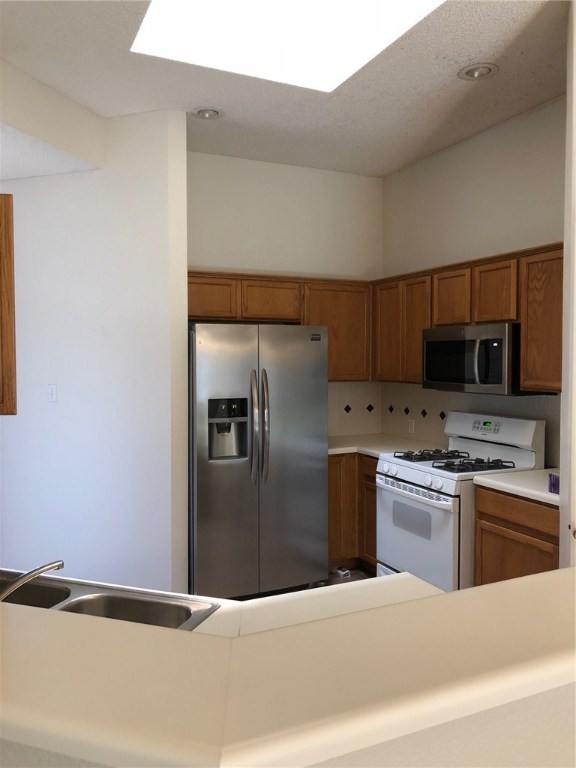7600 Amanda Ellis Way Austin, TX 78749 - Photo 8 of 22 a kitchen with stainless steel appliances granite countertop a refrigerator a stove and a sink with wooden floor