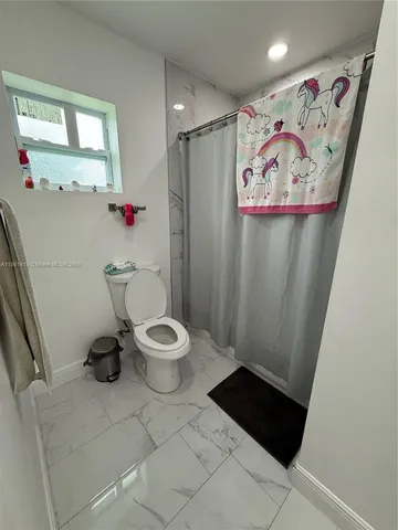 a bathroom with a toilet and a shower