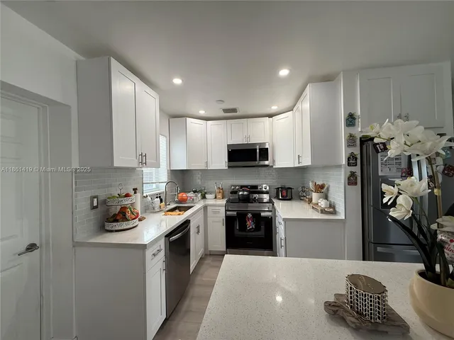 a kitchen with stainless steel appliances granite countertop a sink dishwasher stove top oven and cabinets