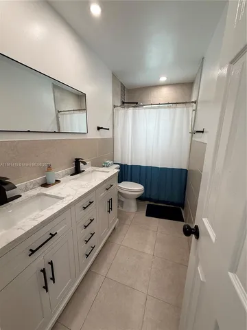 a bathroom with a double vanity sink toilet and shower