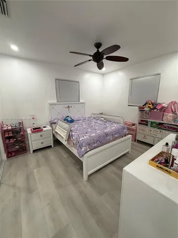 a bedroom with a bed and a ceiling fan