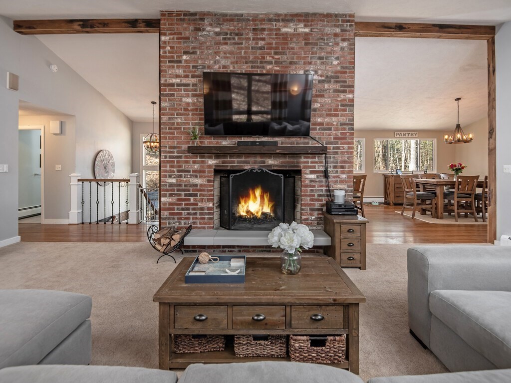 552 Lowell Road Groton, MA 01450 - Photo 5 of 42 a living room with furniture a flat screen tv and a fireplace