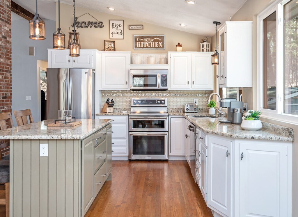 552 Lowell Road Groton, MA 01450 - Photo 10 of 42 a kitchen with stainless steel appliances granite countertop a stove top oven a sink dishwasher and a refrigerator with wooden floor