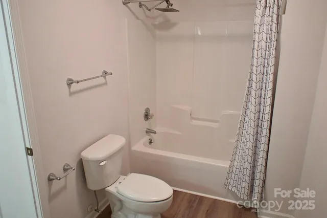 a white toilet sitting next to a bath tub