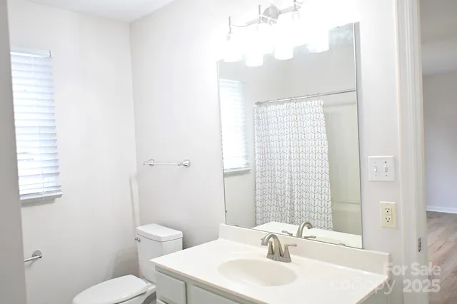 a bathroom with a sink a toilet and shower curtain