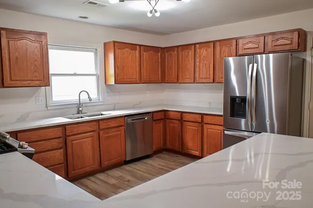 a kitchen with stainless steel appliances granite countertop a refrigerator sink and cabinets