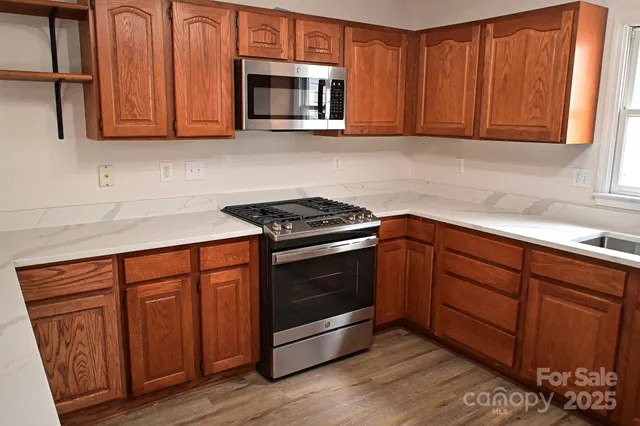 a kitchen with wooden cabinets and a stove top oven