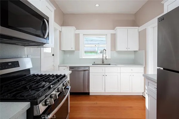 a kitchen with stainless steel appliances granite countertop a stove a sink and a microwave