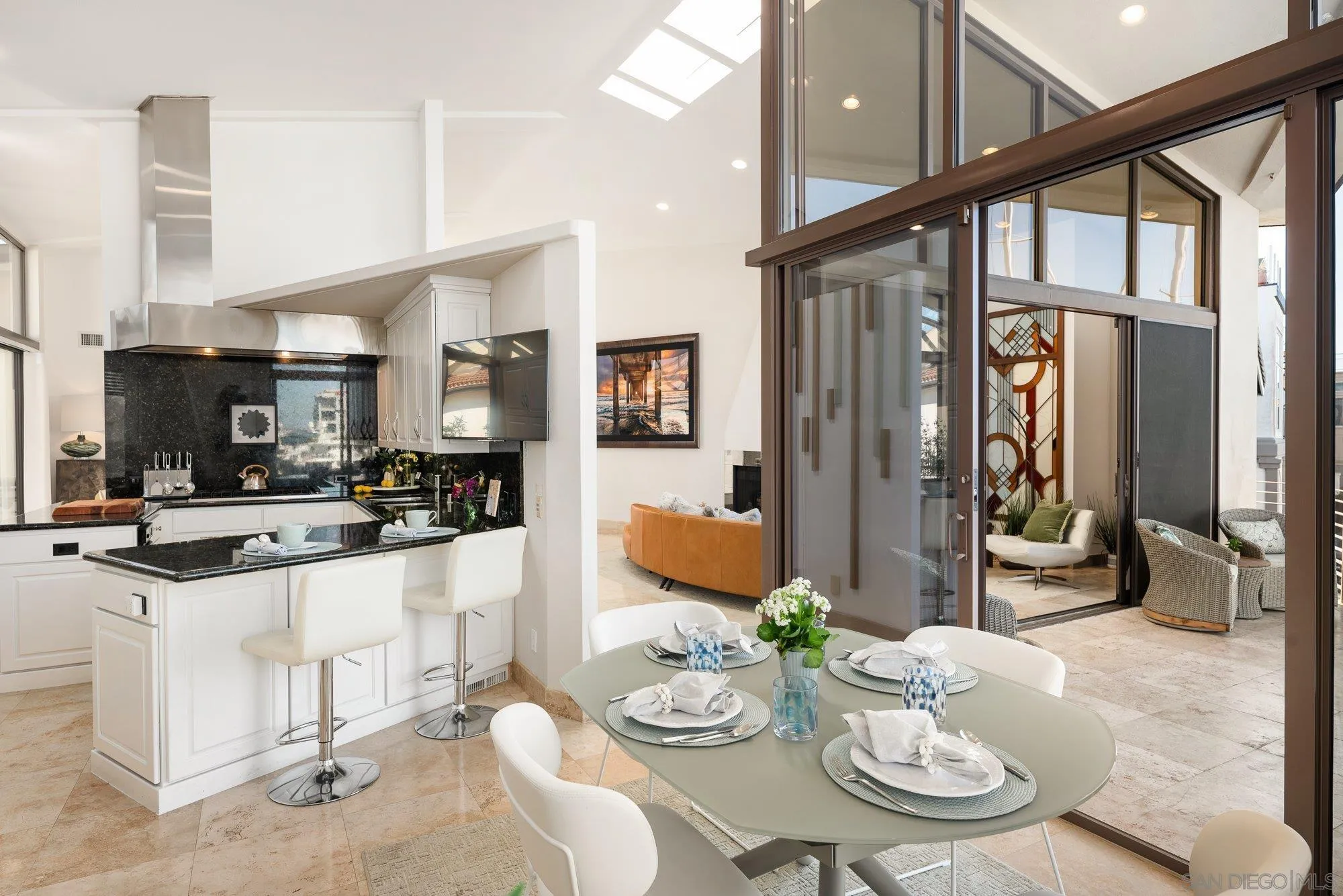 25 The Point Coronado, CA 92118 - Photo 19 of 74 a kitchen with stainless steel appliances couches a dining table and chairs