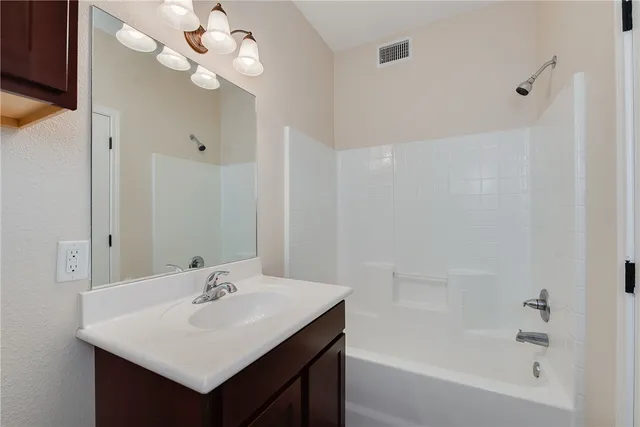 a bathroom with a sink mirror and a bathtub