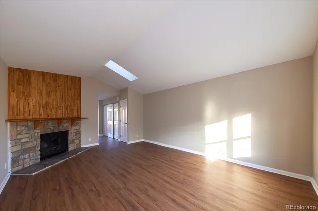 a view of empty room with wooden floor and fireplace