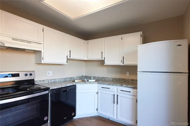 a kitchen with granite countertop cabinets appliances and a counter space