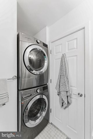 a living room with a black white checkered floor with couches chair and a coffee table