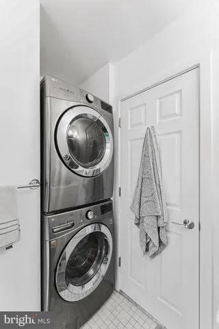 a living room with a black white checkered floor with couches chair and a coffee table