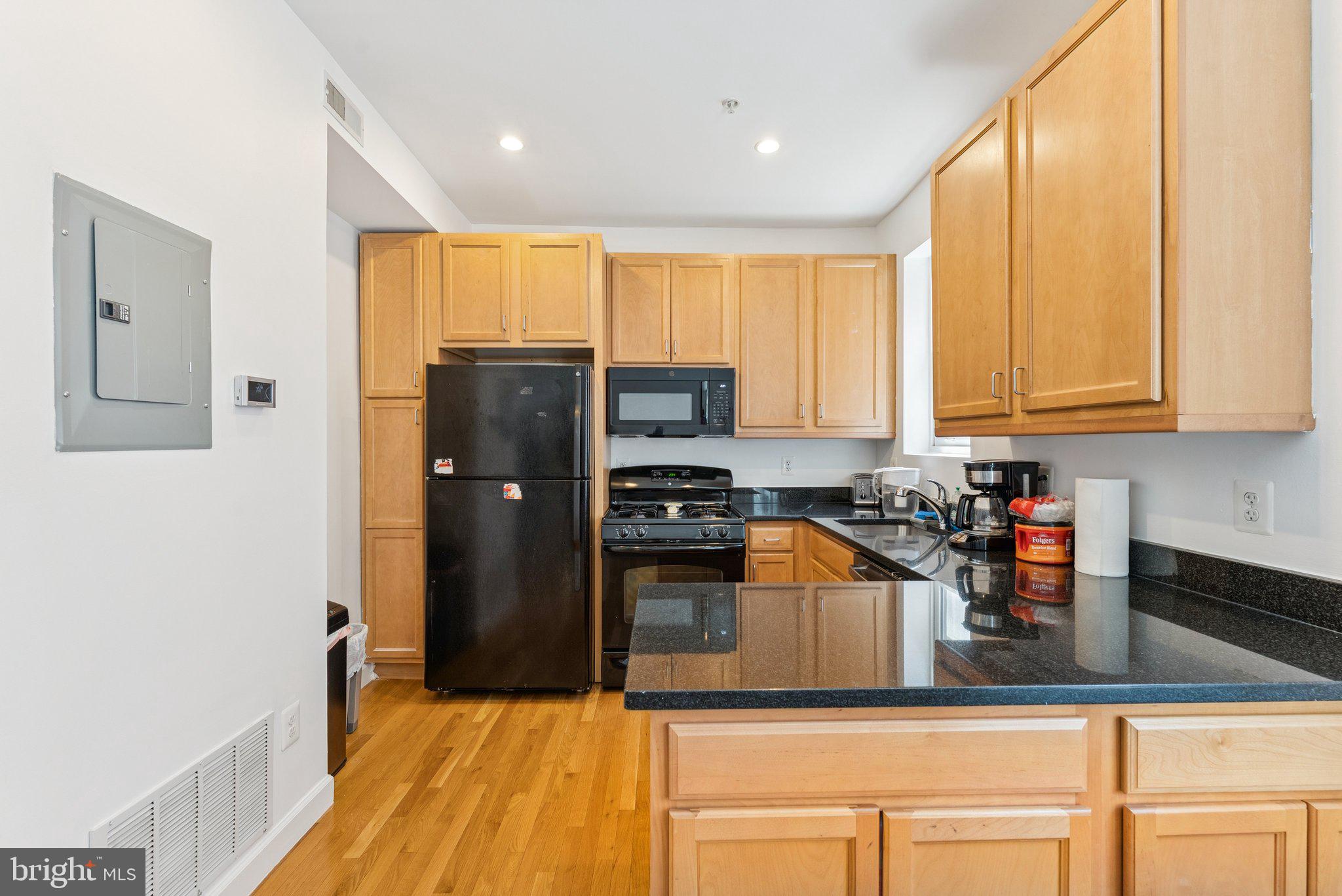 1440 Columbia Road Northwest, Unit 204 Washington, DC 20009 - Photo 7 of 23 a kitchen with stainless steel appliances granite countertop a refrigerator and a stove top oven