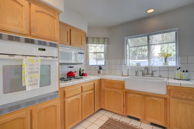 a kitchen with granite countertop a sink window and cabinets