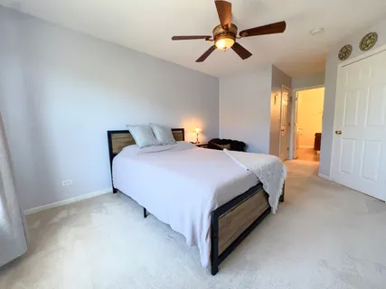 a spacious bedroom with a bed and a ceiling fan