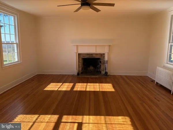 a view of a livingroom with wooden floor and fireplace