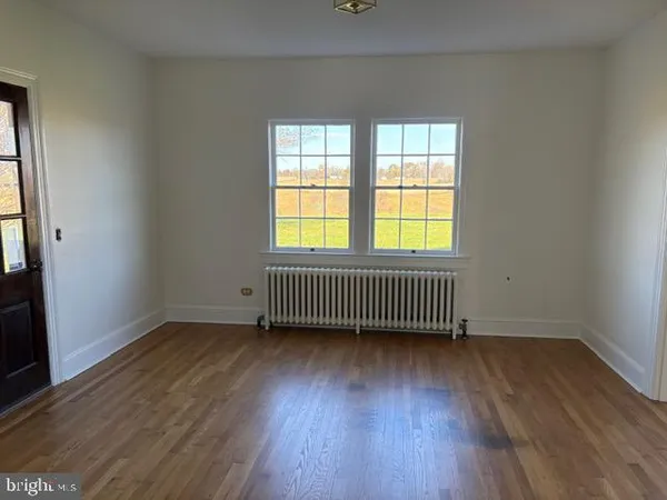 an empty room with wooden floor and a window